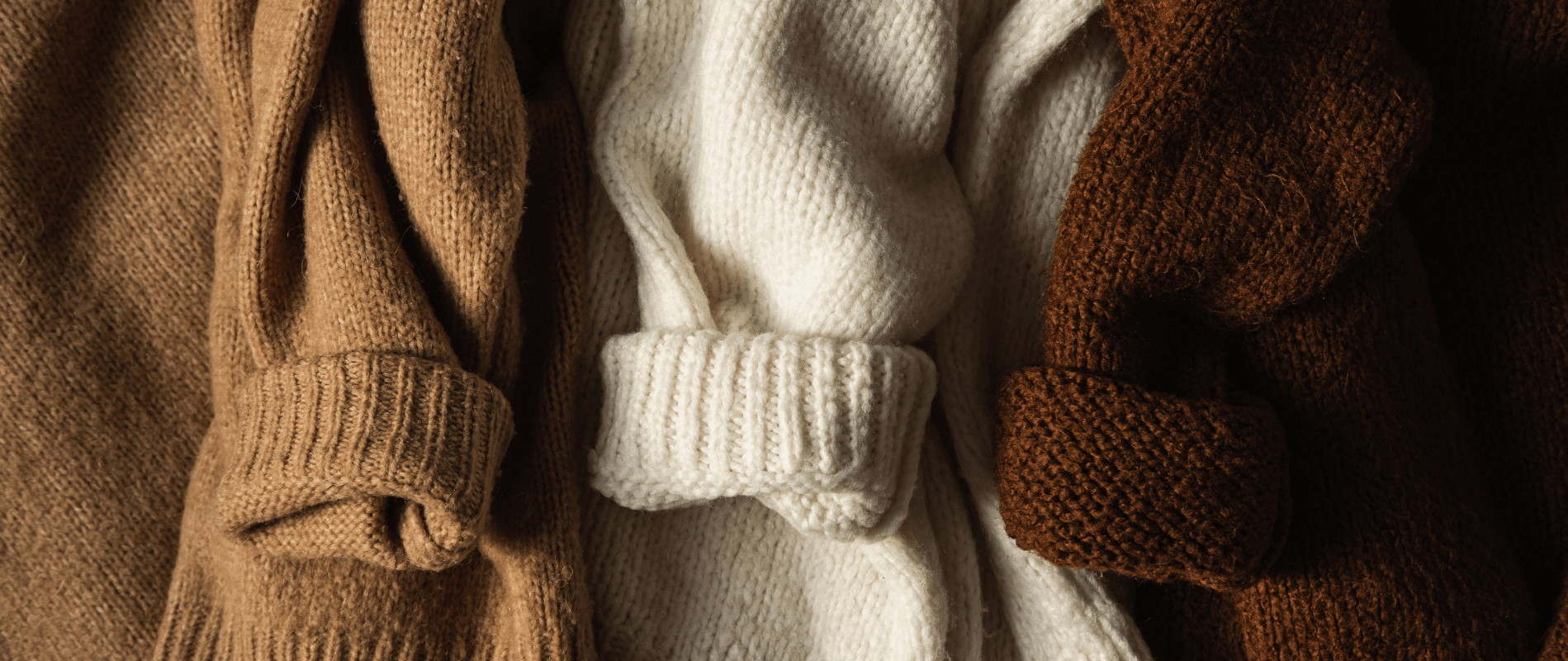 Cozy brown, beige, and white knitted sweaters close-up, perfect for fall and winter fashion warmth. Ideal for stylish layering.