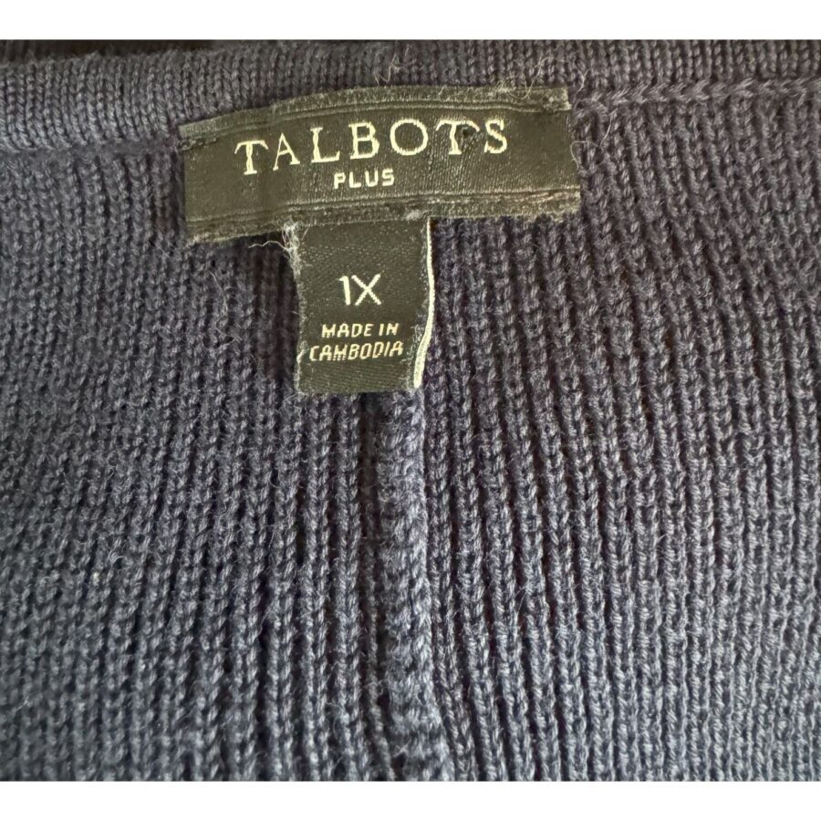 This image shows a Talbots Plus size 1X clothing label on a dark knitted fabric, indicating it is made in Cambodia.