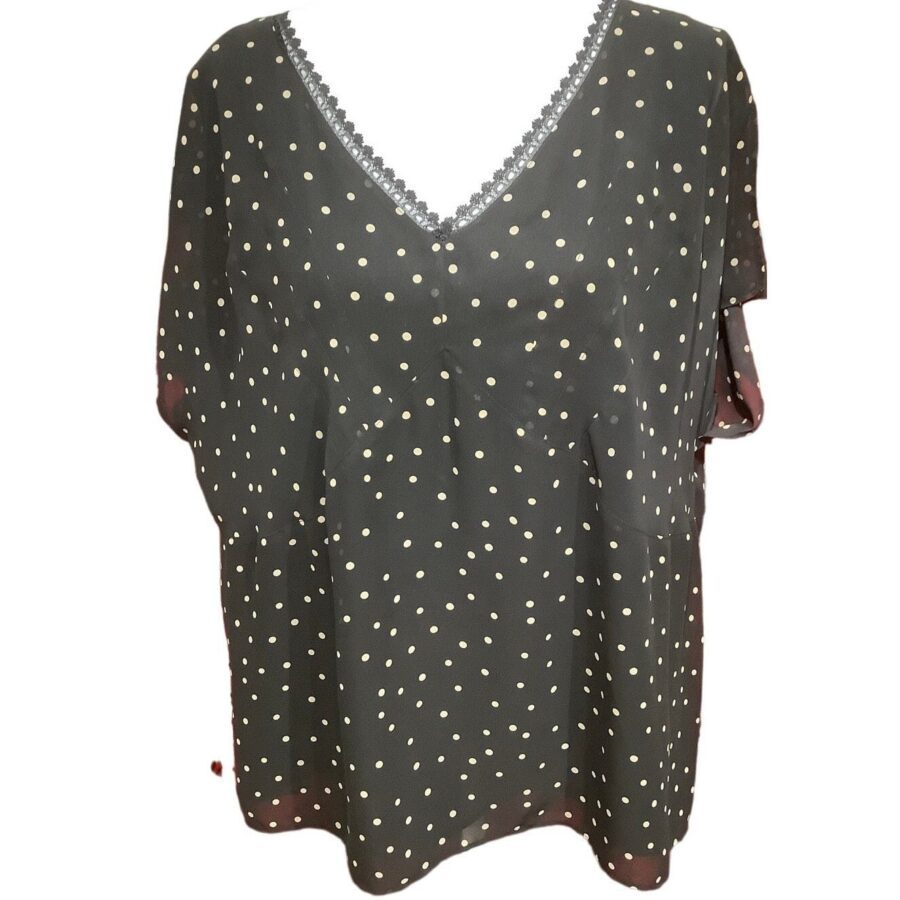 A black blouse with white polka dots and a V-neckline adorned with a lace trim is shown against a plain background.