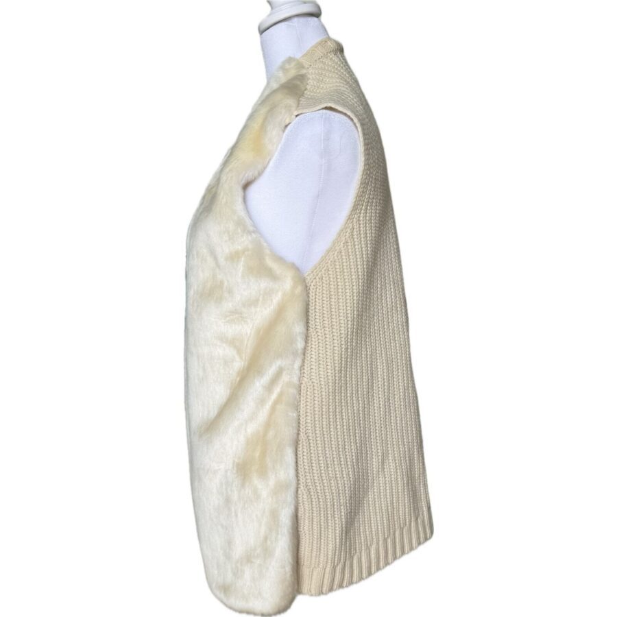 A beige, sleeveless knit vest with a plush, fur-like fabric front, displayed on a white mannequin torso against a white background.