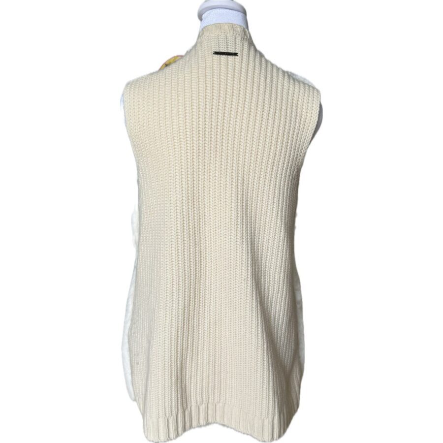 A sleeveless cream-colored knit garment is displayed on a mannequin, showing the back view of the item with a ribbed texture.