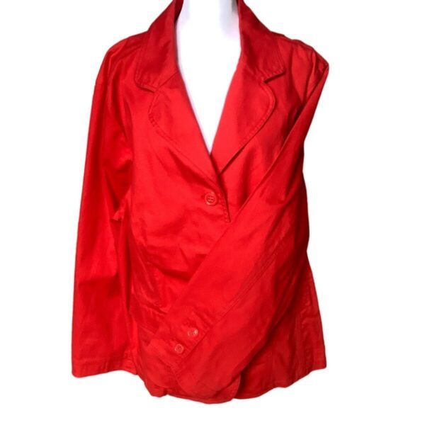 A bright red blazer on a white mannequin torso, featuring a classic design with notched lapels and button closure. Simple and elegant attire.