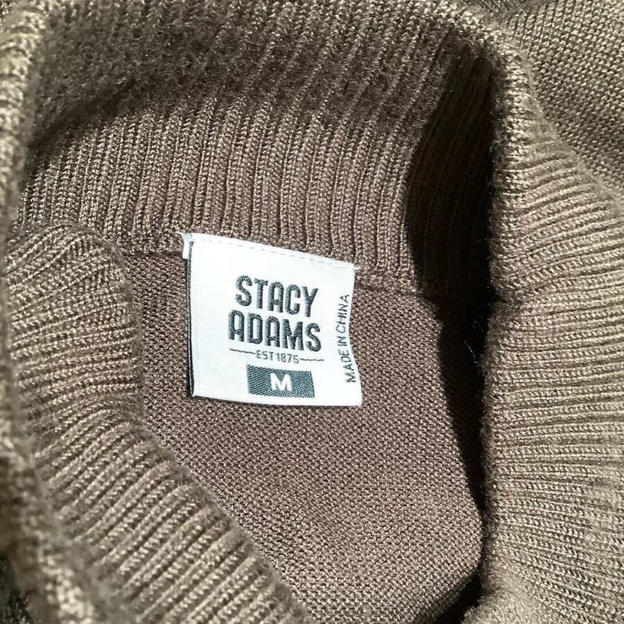 A close-up of a brown sweater with a "Stacy Adams" clothing tag, indicating size medium and made in China.