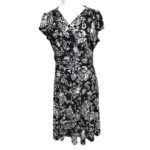 A black and white floral-patterned wrap dress displayed on a mannequin against a white background. The dress features short sleeves and a v-neckline.