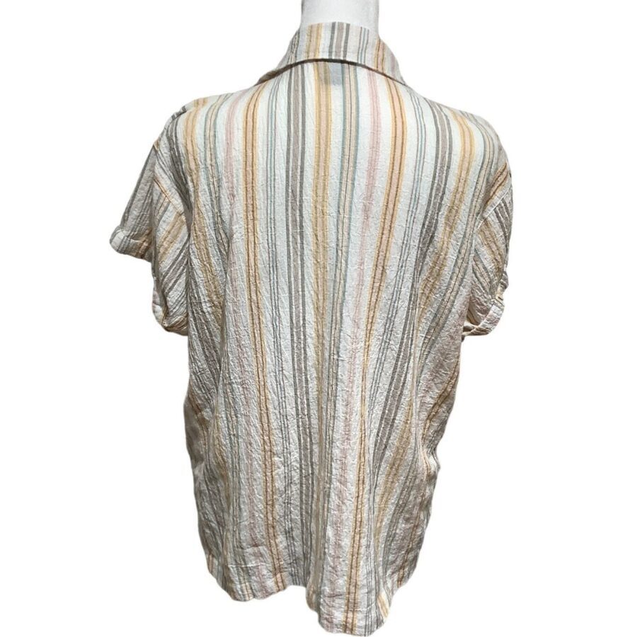 A striped shirt displayed on a mannequin, showcasing various shades of beige, brown, and white with a light, airy fabric.