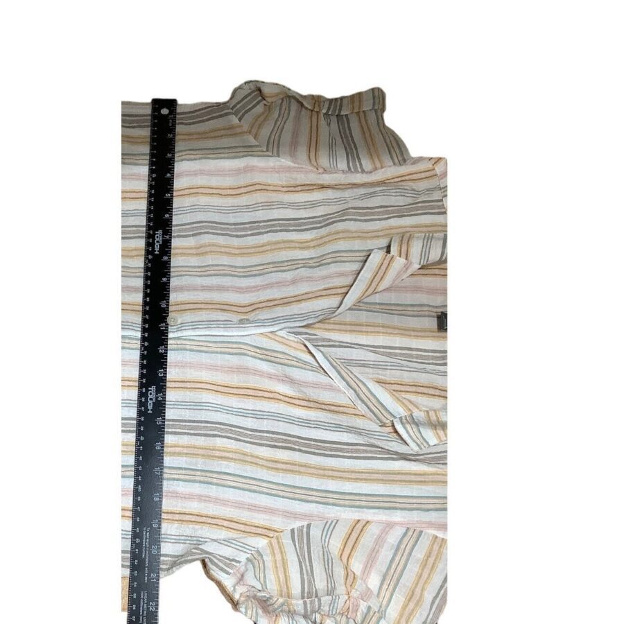 A striped garment is measured with a ruler. The fabric has horizontal stripes in various colors. The garment appears to be neatly folded.