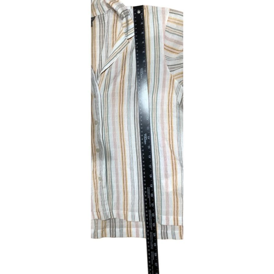 A striped, button-up shirt on a flat surface, measured by a black ruler across its length, reaching from collar to hem.