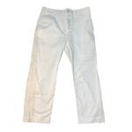 The image shows a pair of plain white pants. They have a button closure and slightly wrinkled fabric, laid flat against a white background.