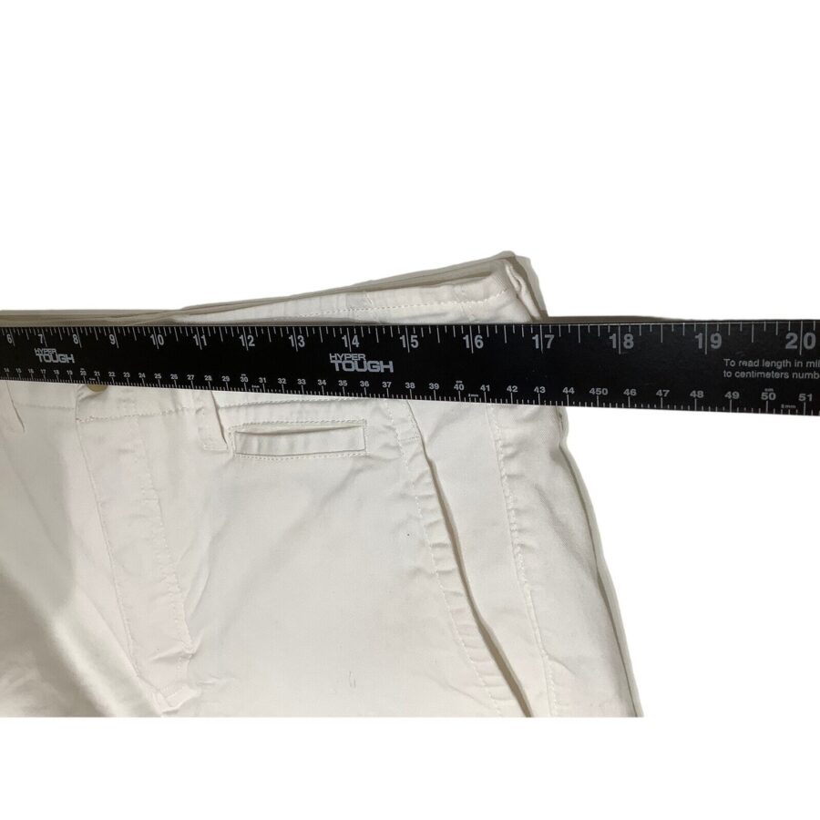 A pair of white pants is measured with a black ruler, indicating a waist size of 19 inches from seam to seam.