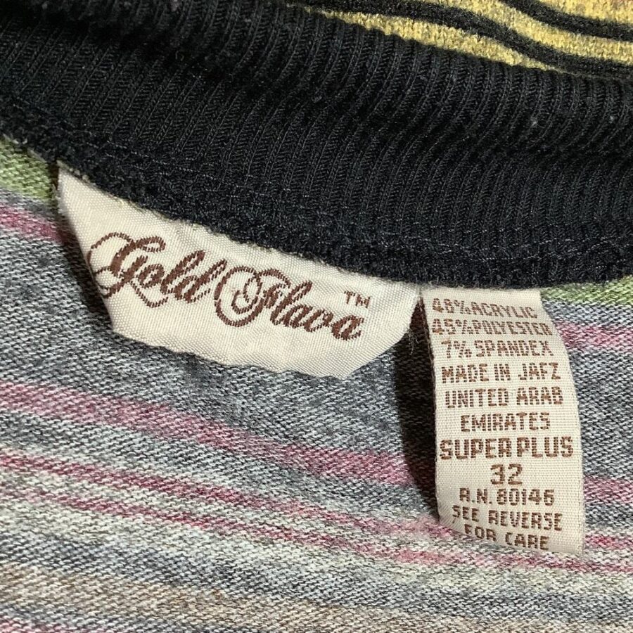 A label on a garment reads “Gold Flare” and details the fabric composition, origin (JAFZ, UAE), and care instructions. Fabrics include acrylic, polyester, and spandex.