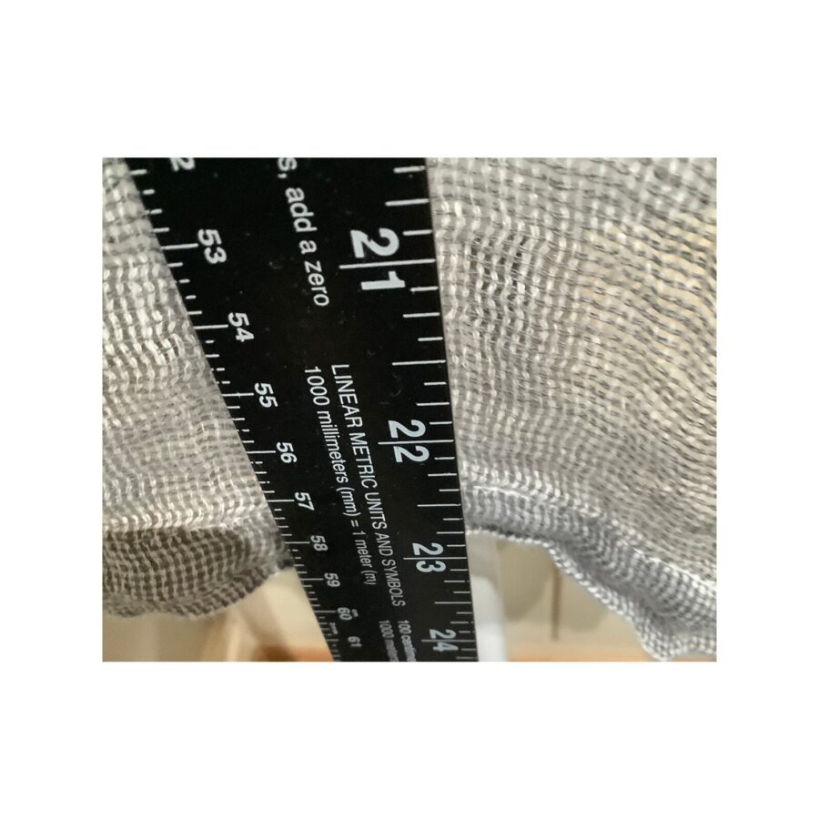 The image shows a close-up of a ruler measuring a piece of silver mesh fabric. The measurement is approximately 21 inches.