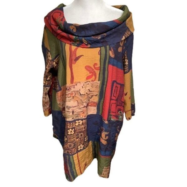 A multicolored, patterned shawl draped over a stand, featuring intricate designs and a cowl neckline. No recognizable landmarks or historical buildings visible.