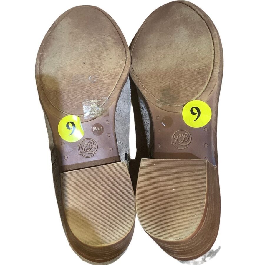 The image shows the soles of a pair of shoes labeled with yellow circular stickers displaying the number 9 on each sole.