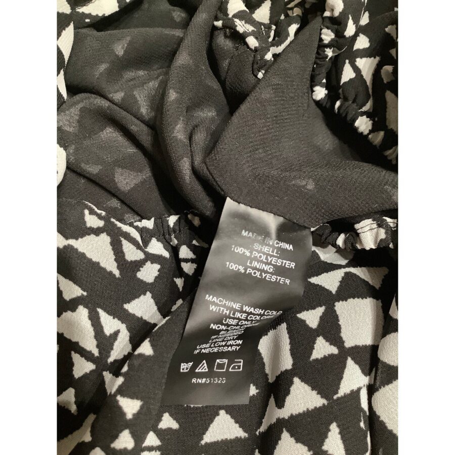 A black and white patterned fabric with a tag indicating material (polyester) and care instructions. The garment is made in China.