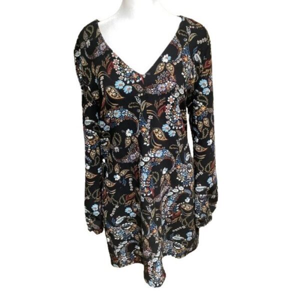 A black long-sleeve dress featuring a floral and paisley pattern on a white mannequin. The dress has a V-neck design and colorful prints.