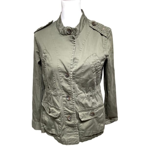 A green military-style jacket with multiple buttons and pockets displayed on a white mannequin torso. No landmarks or historical buildings are visible.