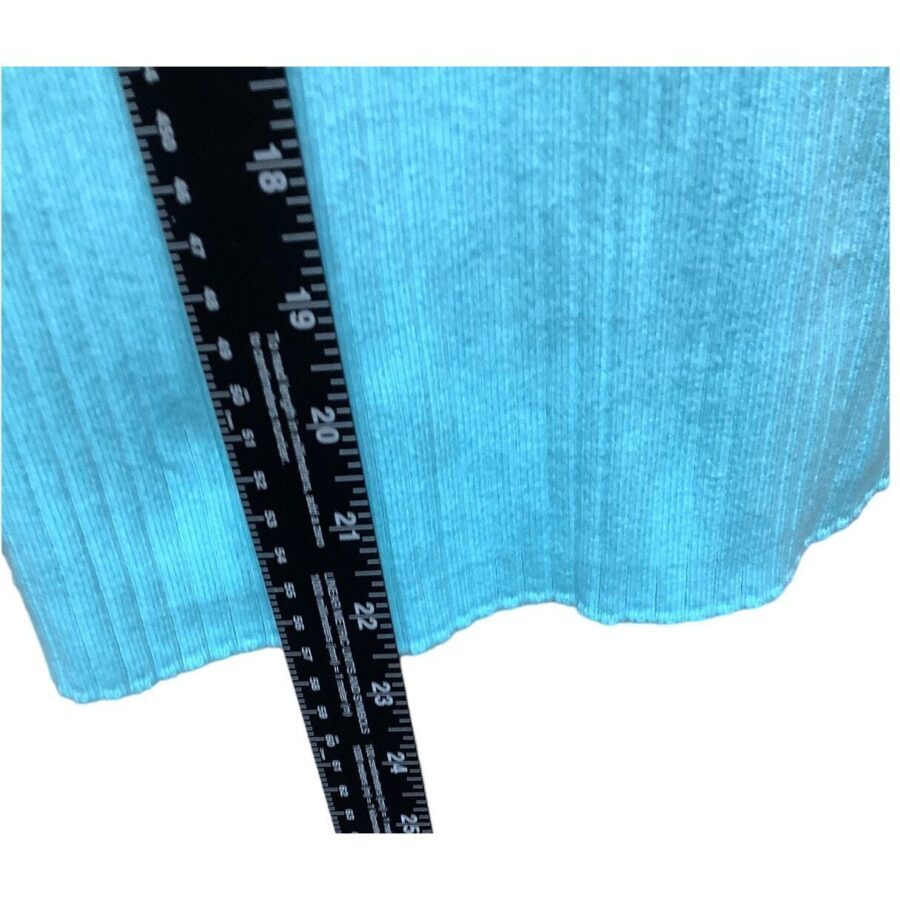 A blue, ribbed fabric is measured with a black ruler, showing centimeter markings from 8 to 21. No landmarks or historical buildings visible.