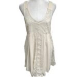 A sleeveless beige dress with floral embroidery on the bodice and skirt, displayed on a mannequin torso against a plain white background.