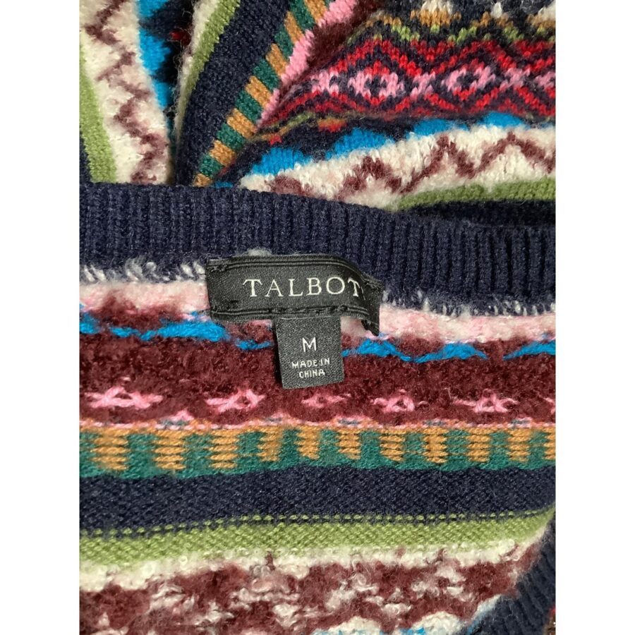 A colorful knitted sweater showing intricate patterns and a label reading "TALBOT M MADE IN CHINA." No recognizable landmarks or historical buildings are visible.