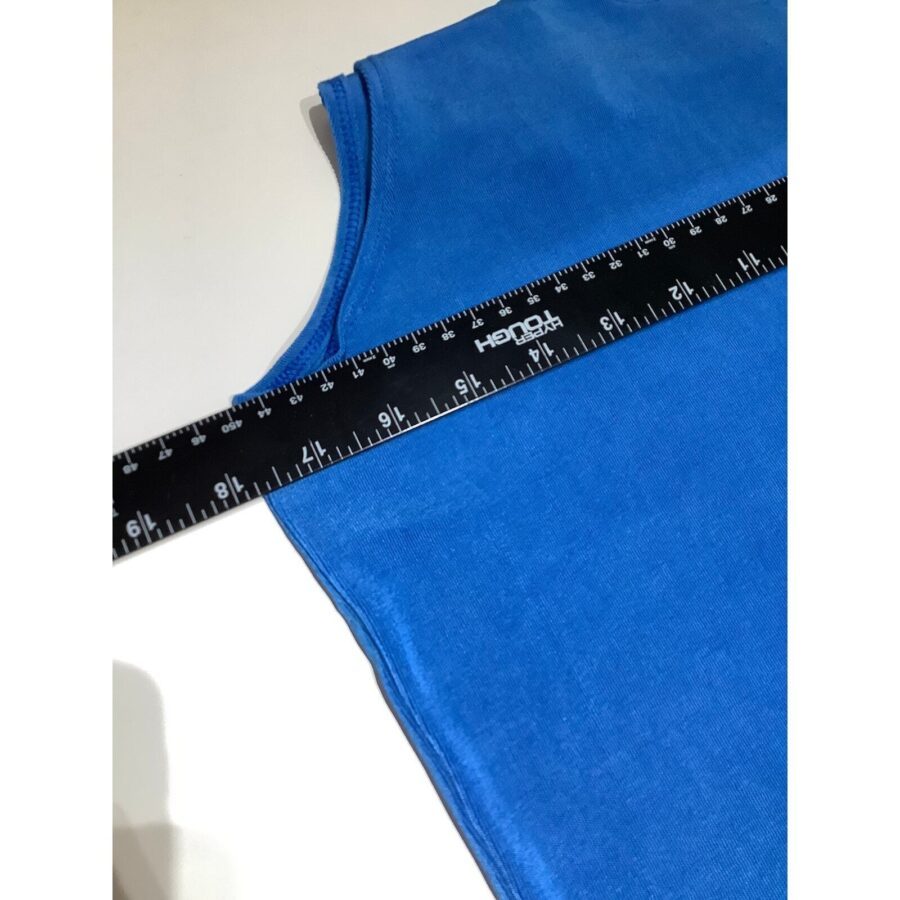 A blue fabric with a black measuring ruler placed on it, showing inches and centimeters for measurement. No landmarks or historical buildings visible.