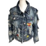 Denim jacket with patches and distressing displayed on a mannequin. Patches include "girl gang," "LOVE," a rose, and a star.