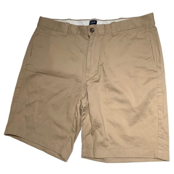 A pair of khaki shorts with front pockets, belt loops, and a button closure is displayed. There are no recognizable landmarks or historical buildings.