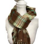 A mannequin dressed in a plaid scarf with shades of green, brown, and beige, displayed on a white stand.