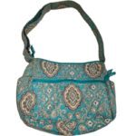 A teal fabric shoulder bag with paisley patterns and a zippered front pocket. The strap is wide, matching the bag's design.