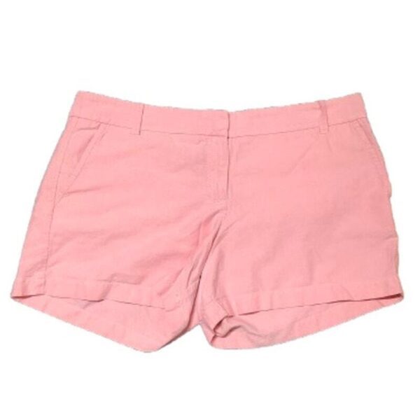 A pair of pink, tailored shorts with belt loops and front pockets is neatly displayed against a white background. No landmarks or historical buildings present.