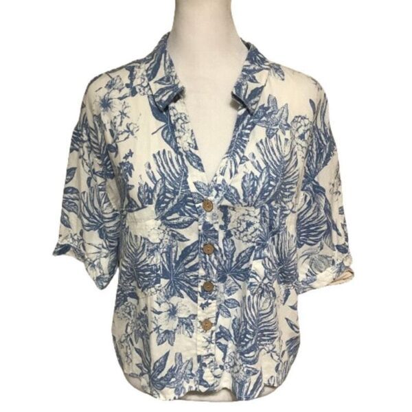 A white and blue floral-patterned button-up shirt displayed on a mannequin torso, featuring short sleeves and a casual design.