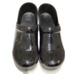 A pair of shiny black clogs with a round toe and elevated heel, set against a plain white background. No landmarks or historical buildings.