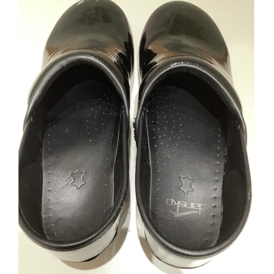 A pair of black leather clogs is shown from the top, displaying the brand "Dansko" on the insoles.