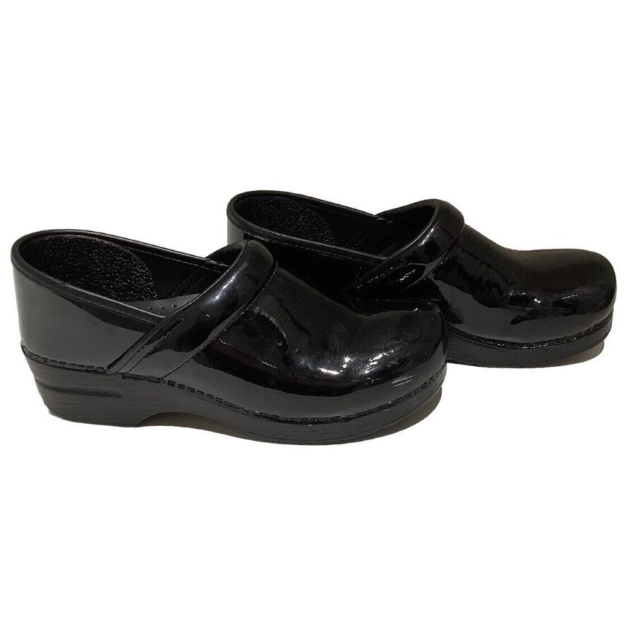 A pair of black, shiny, closed-toe clogs with a strap across the instep, featuring a thick sole. The shoes are positioned side by side.