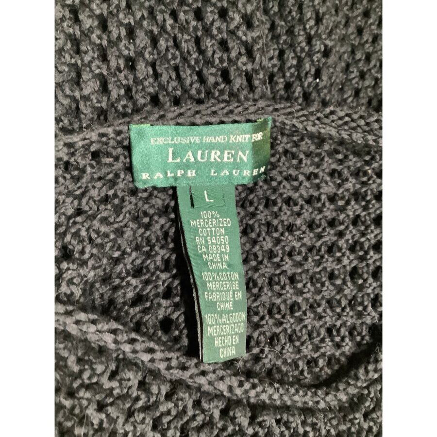 A close-up of a black knitted fabric with a green "Lauren Ralph Lauren" label indicating it is hand-knit and made of 100% mercerized cotton.