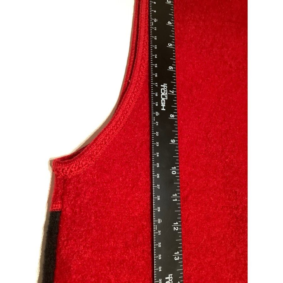 A close-up image showing a red wool fabric next to a black ruler with white markings, measuring approximately 14 inches in length.