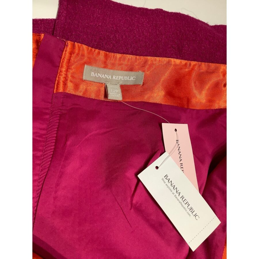 A close-up of a Banana Republic garment with pink exterior and orange lining, displaying tags and labels. No landmarks or historical buildings present.