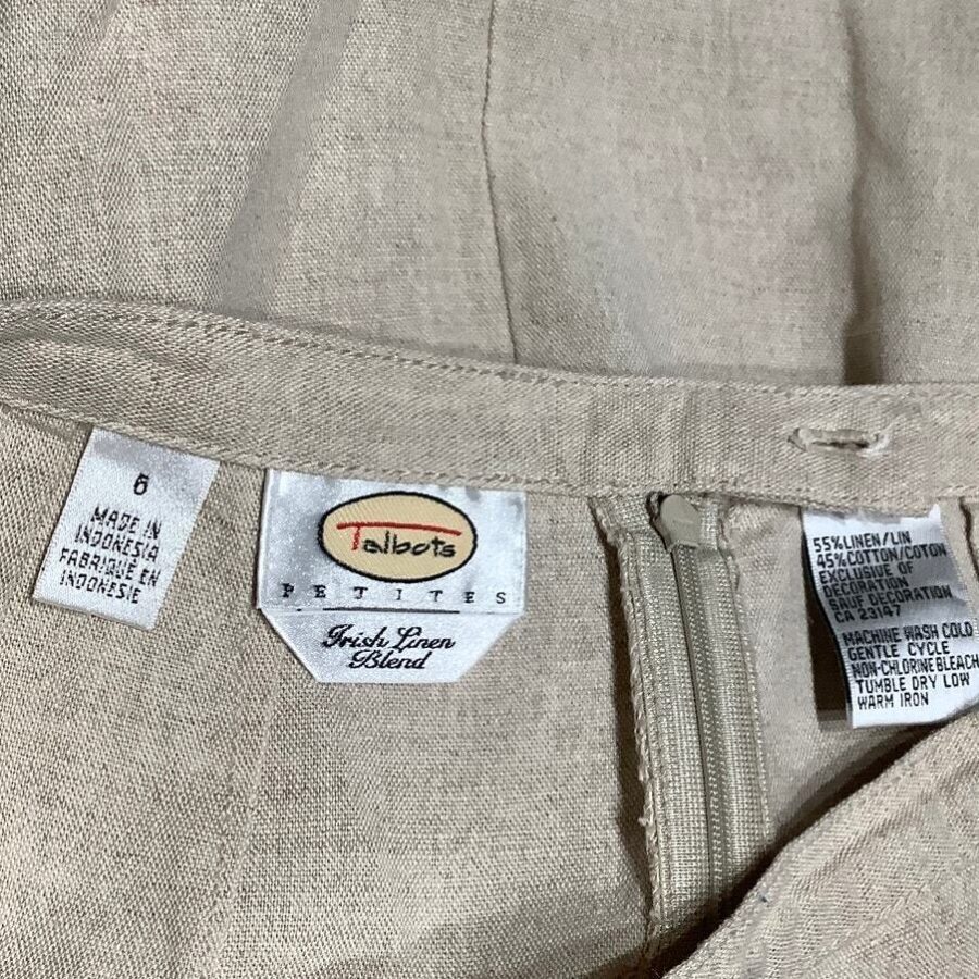 A close-up image of a beige garment featuring Talbots label, indicating it's Irish linen blend, and tags showing size, fabric composition, and care instructions.