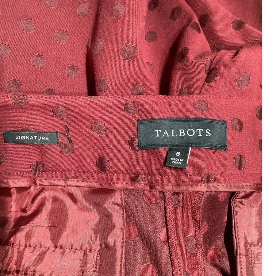 A close-up image of a red, polka-dotted fabric with "Talbots" and "Signature" labels, indicating the clothing brand and size 6, made in China.