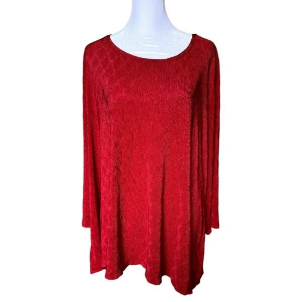 A red, long-sleeve, A-line top is displayed on a white mannequin torso, showcasing a textured fabric with a round neckline against a plain background.