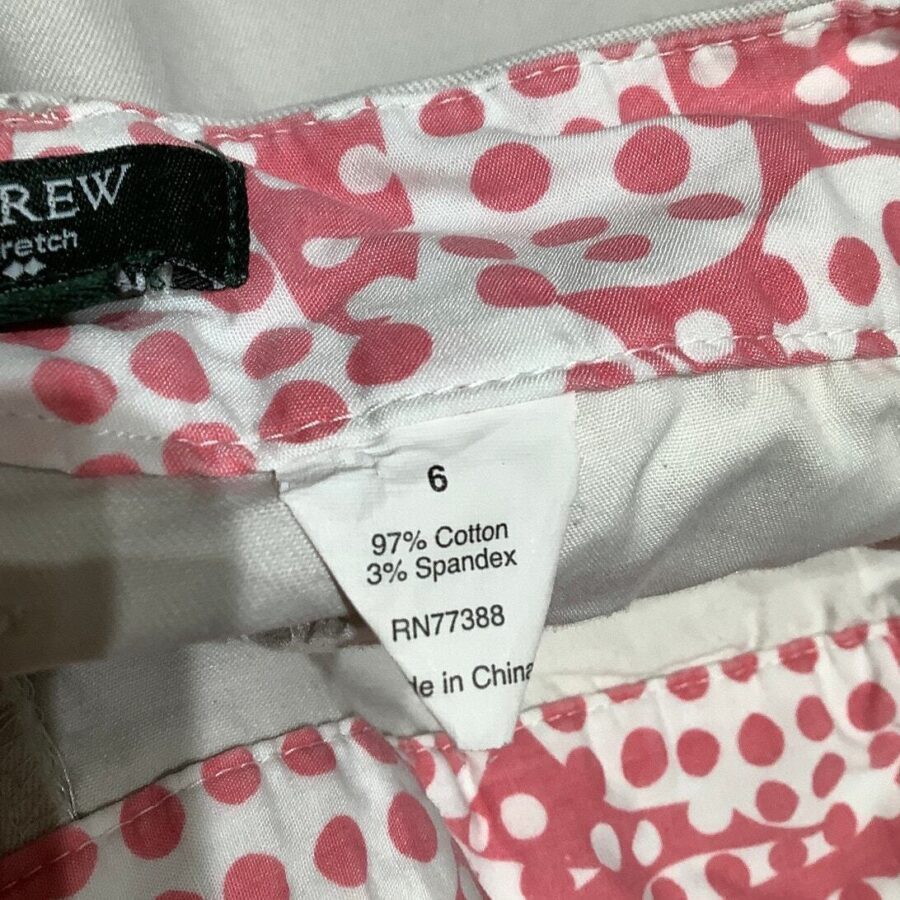 A pink and white polka dot fabric with a label indicating 97% cotton, 3% spandex, and size 6. Made in China.