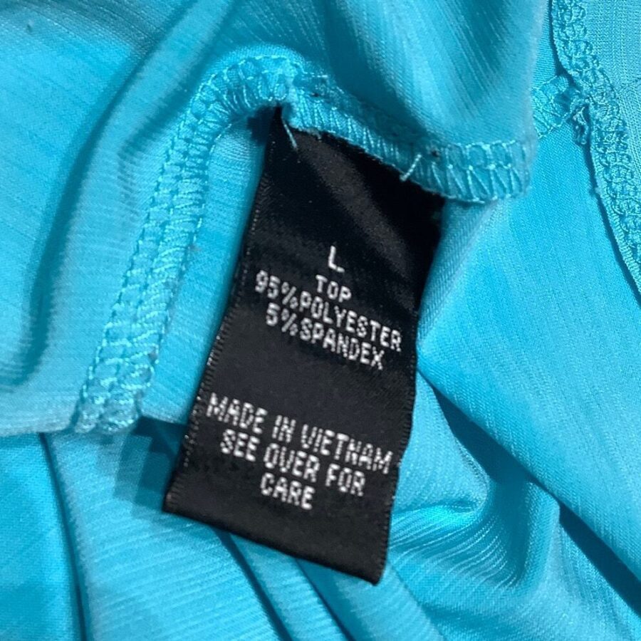 A black clothing tag on a blue garment shows size "L", material (95% polyester, 5% spandex), and "Made in Vietnam."