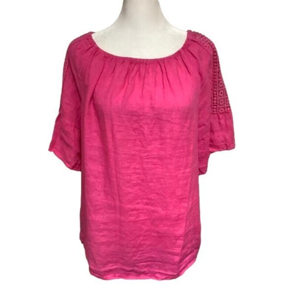 A pink, short-sleeved blouse with a gathered neckline and lace detail on the sleeves is displayed on a mannequin torso.