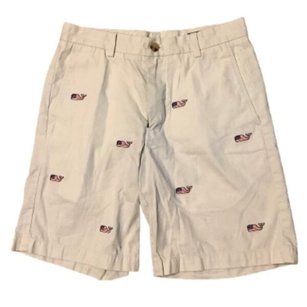 Beige shorts featuring an embroidered whale pattern. Each whale has an American flag design. The shorts have belt loops, side pockets, and a button closure.