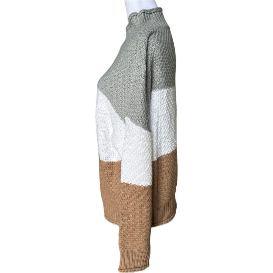 A side view of a color-block knitted sweater with grey, white, and tan sections. The sweater has a ribbed neckline, cuffs, and hem.