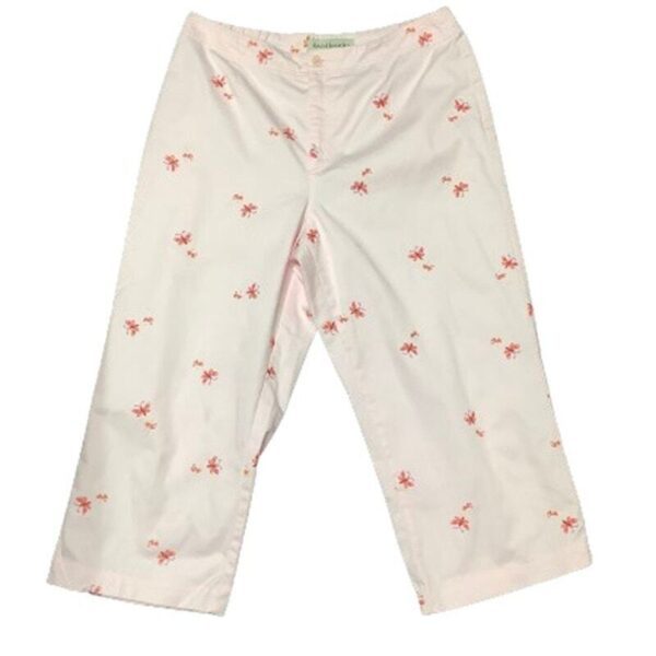 Light pink pants with a wide leg and floral print design scattered across the fabric. The pants have a front zipper and button closure.