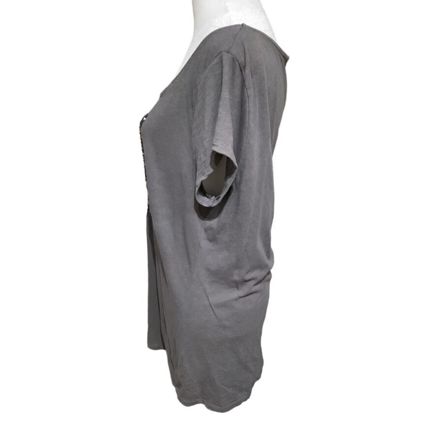 A gray short-sleeve shirt is displayed on a mannequin, viewed from the side, against a white background. No landmarks or historical buildings present.