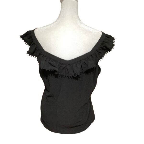 A black, off-the-shoulder top with ruffled trim is displayed on a mannequin from a back view. The background is plain white.