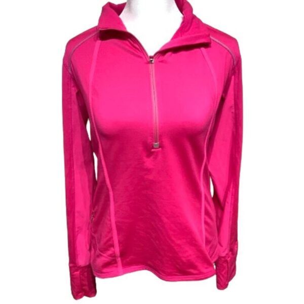 A hot pink long-sleeved athletic top with a half-zip neckline is displayed on a mannequin. Clean, simple design with no additional embellishments.