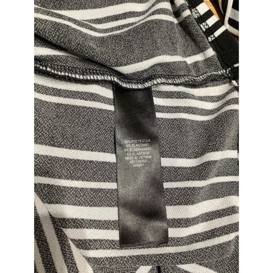 A close-up of a striped fabric with a black label showing material composition and manufacturing details.