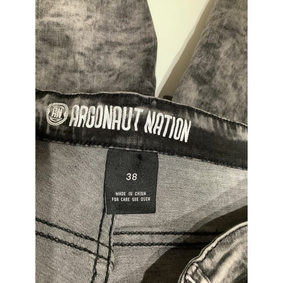 Close-up of the waistband inside a pair of grey jeans, showing the brand name "Argonaut Nation" and size tag "38", indicating manufacturing in China.